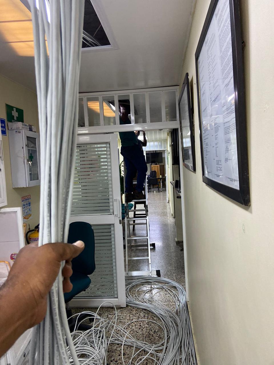 TecnoPacific technician installing structured cabling in an office